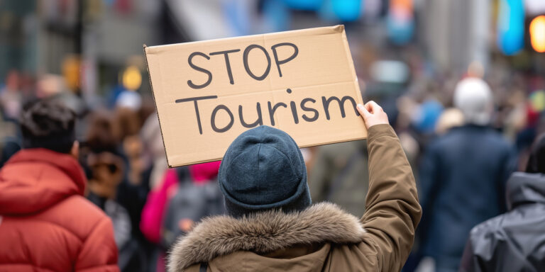 Activist holding stop tourism sign protesting against overtourism issues